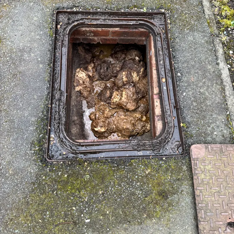A brick manhole standing full of foul waste because the run below it is blocked